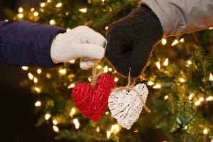 Romantic winter, hands in mittens holding hearts