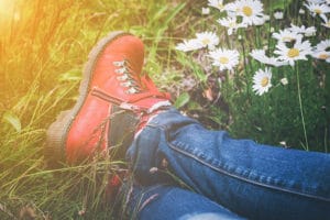 person wearing hiking boot surrounded by spring flowers