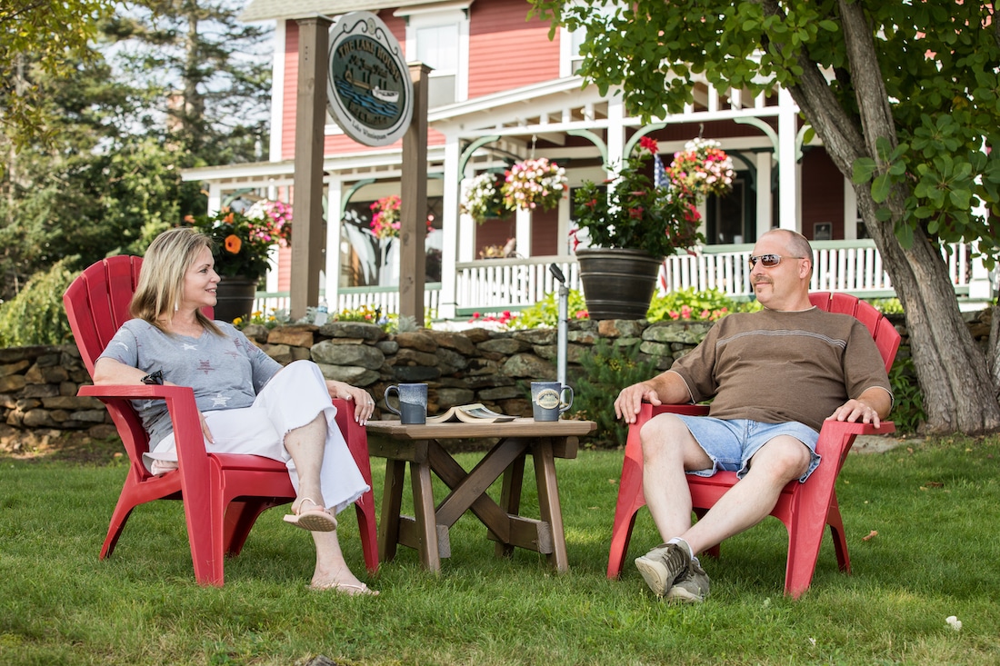 New Hampshire Bed and Breakfast, photo of happy couple sitting outside the Lake House at Ferry Point Inn