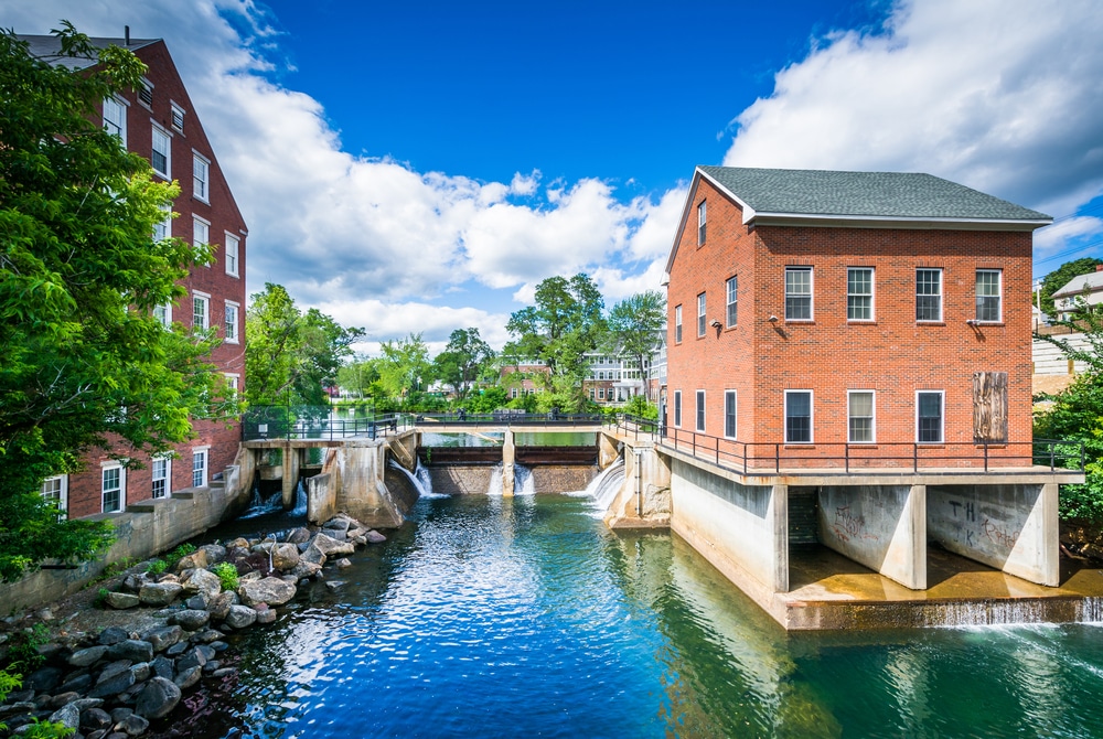 View of historic buildings on the river - one of the best things to do in Laconia, NH