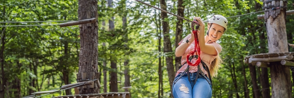 Woman enjoying ziplinging at mountain resorts like Gunstock Mountain Resort in New Hampshire